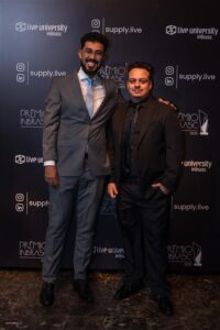 Jeferson Anjos, CEO & Founder da Supply Brain, ao lado de Glauber Almeida, Co-Founder e CTO, posando no Prêmio Inbrasc 2025 diante do painel oficial do evento.