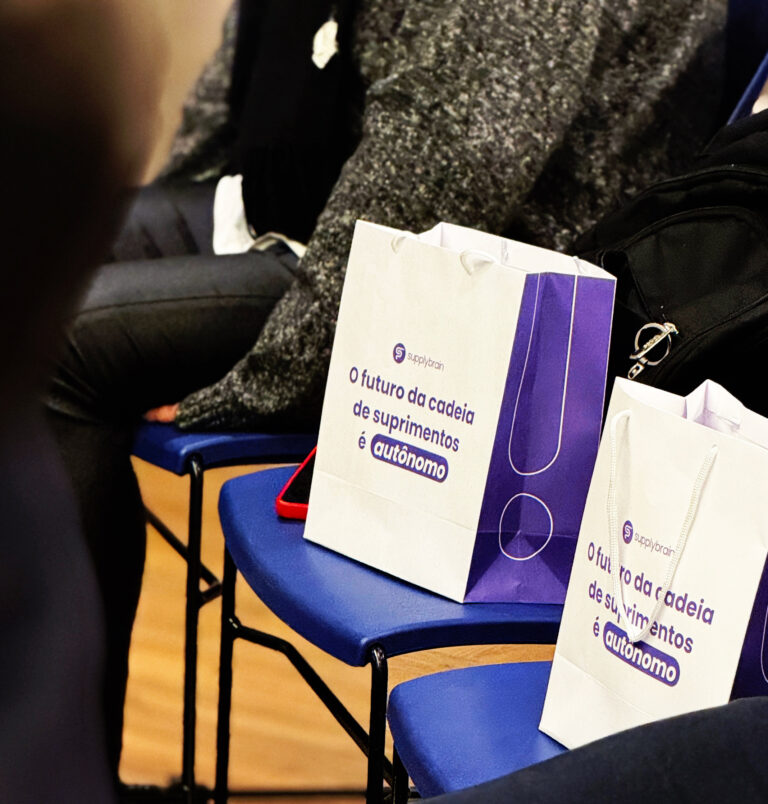 Sacolas da Supply Brain com a frase O futuro da cadeia de suprimentos é autônomo, nas cadeiras do evento